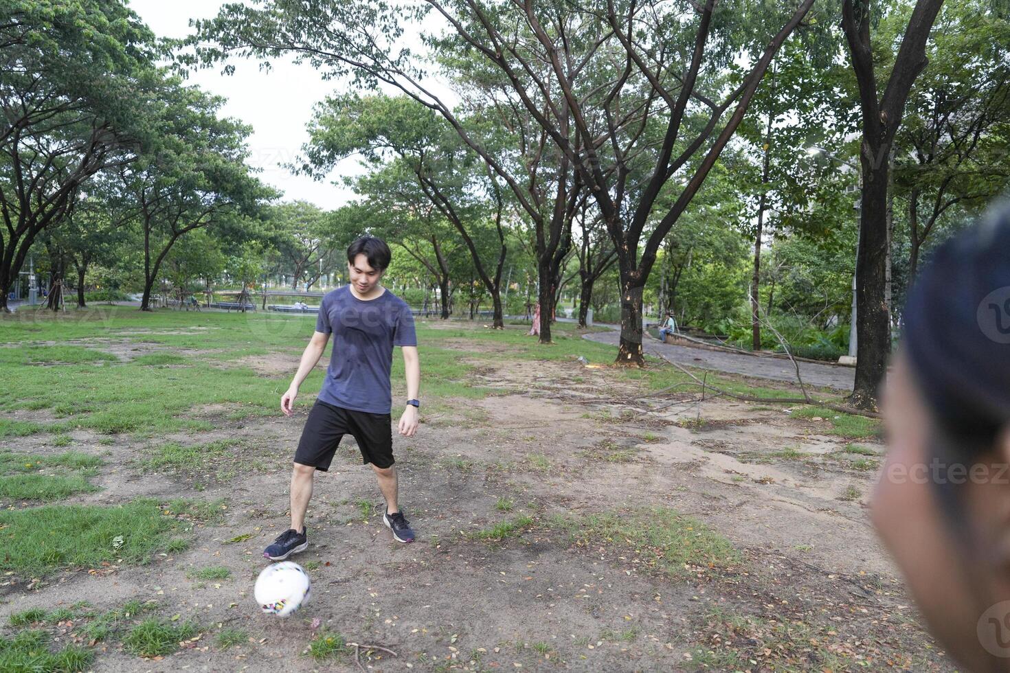 Male and female soccer players practice using the ball in the park field diligently and happily. photo