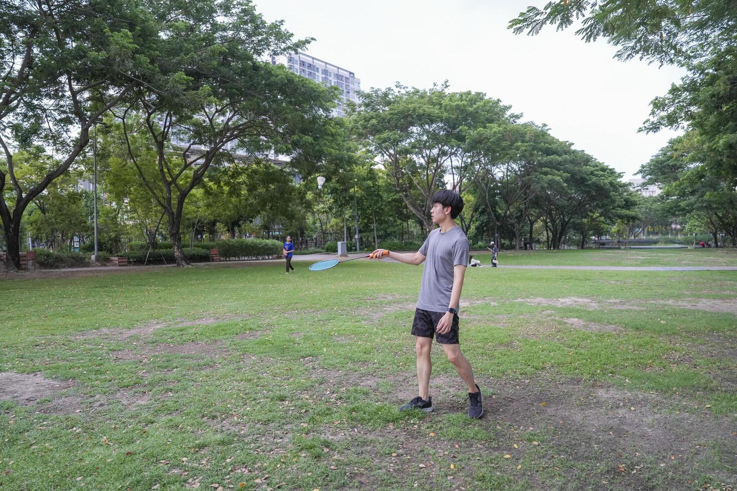 Young people play badminton and repair diligently in the park area. photo