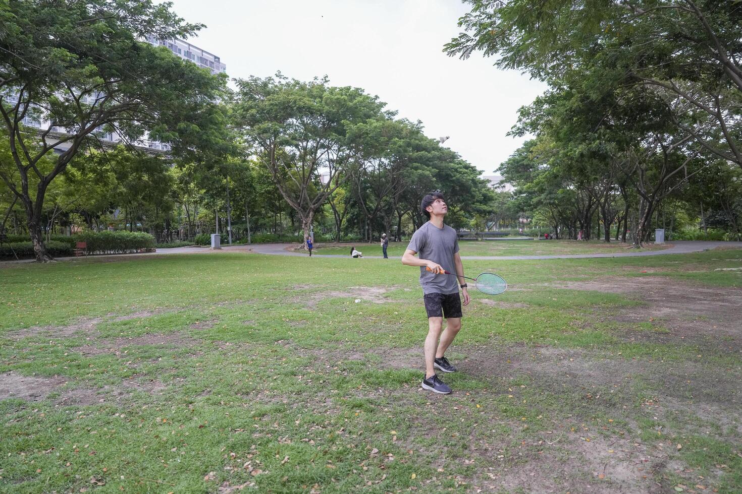 Young people play badminton and repair diligently in the park area. photo