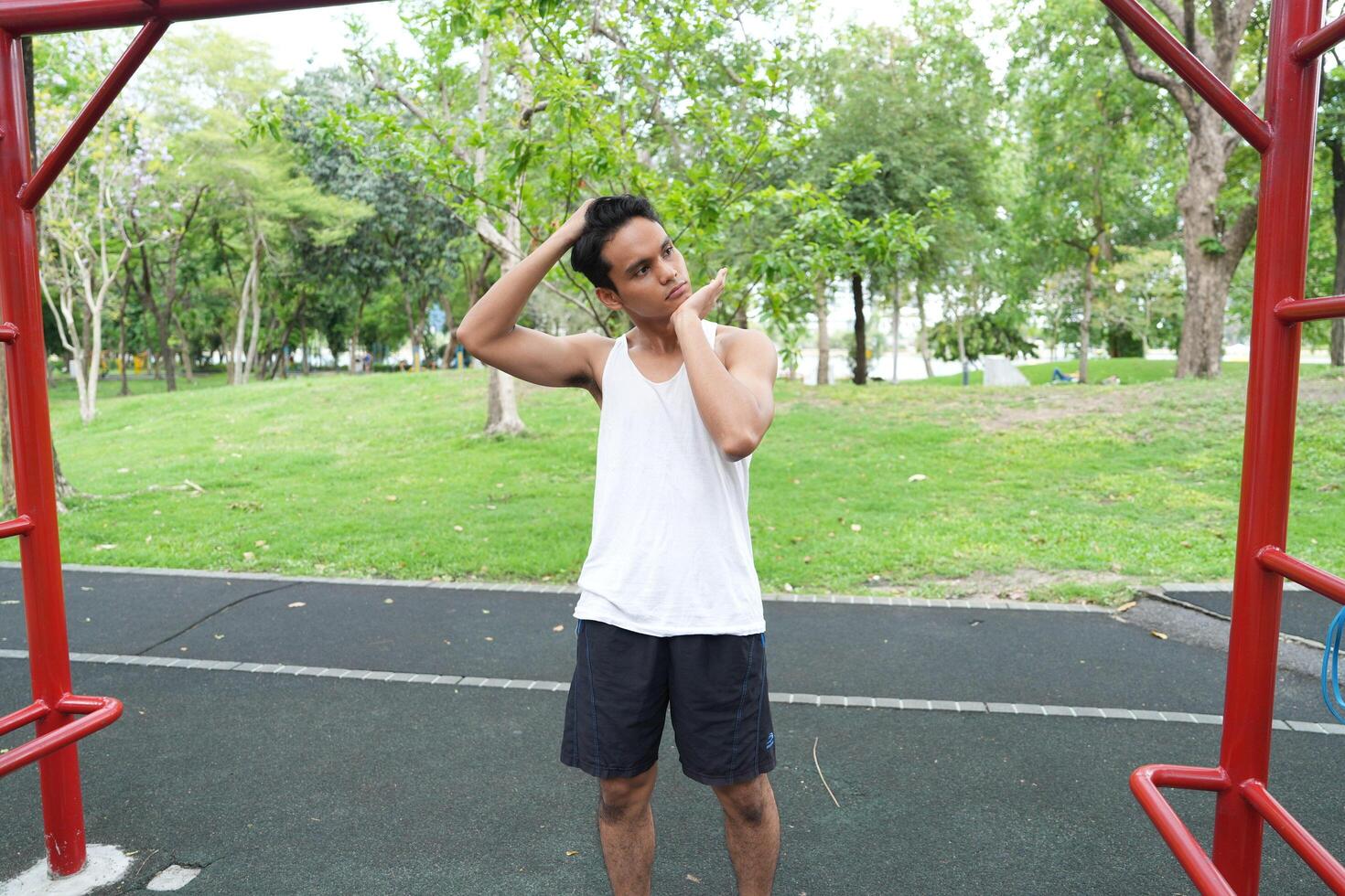 Asian man practicing gymnastics doing gymnastics bar and hoop exercises and stretching and resting for sports. photo