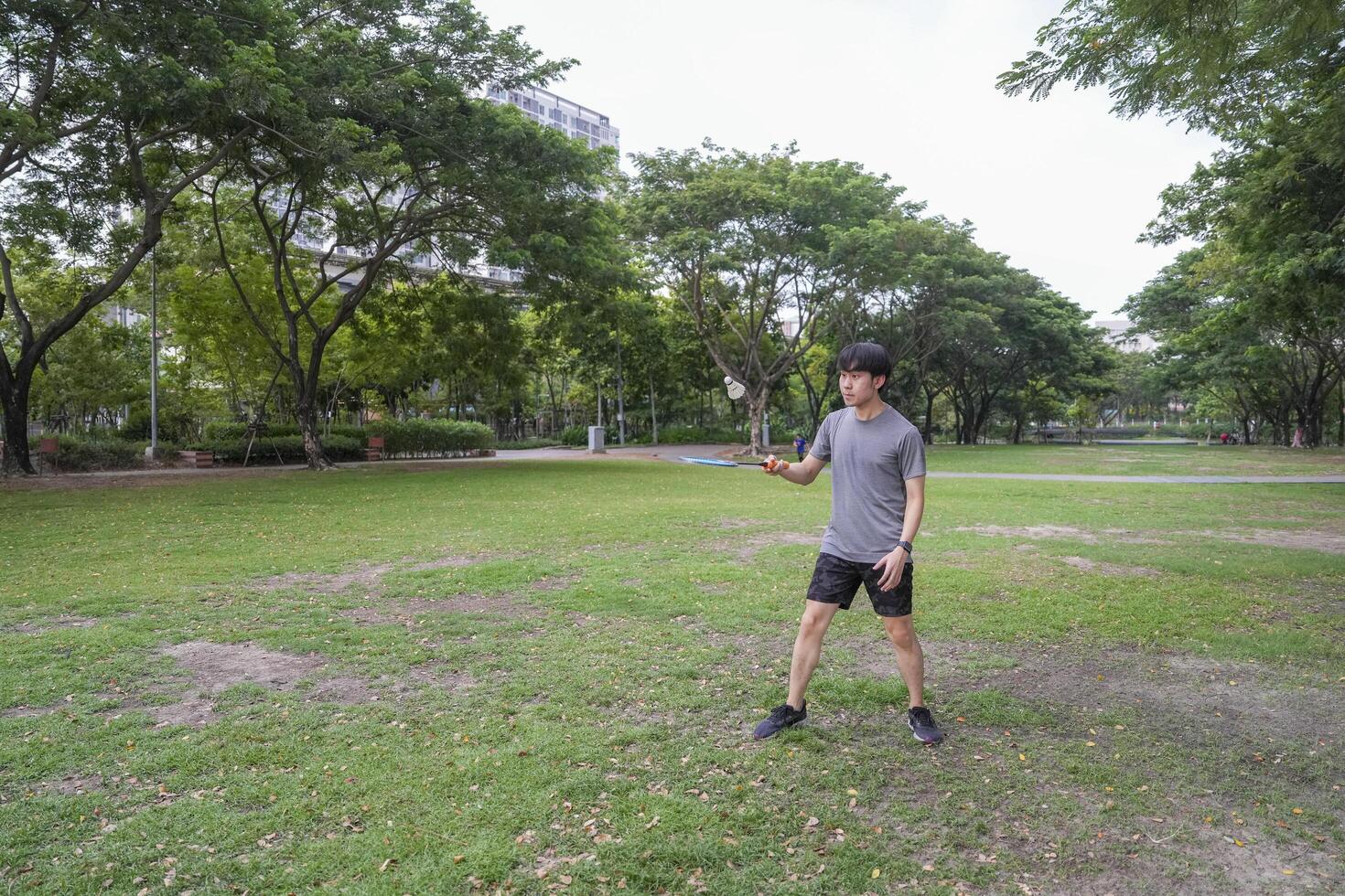 Young people play badminton and repair diligently in the park area. photo