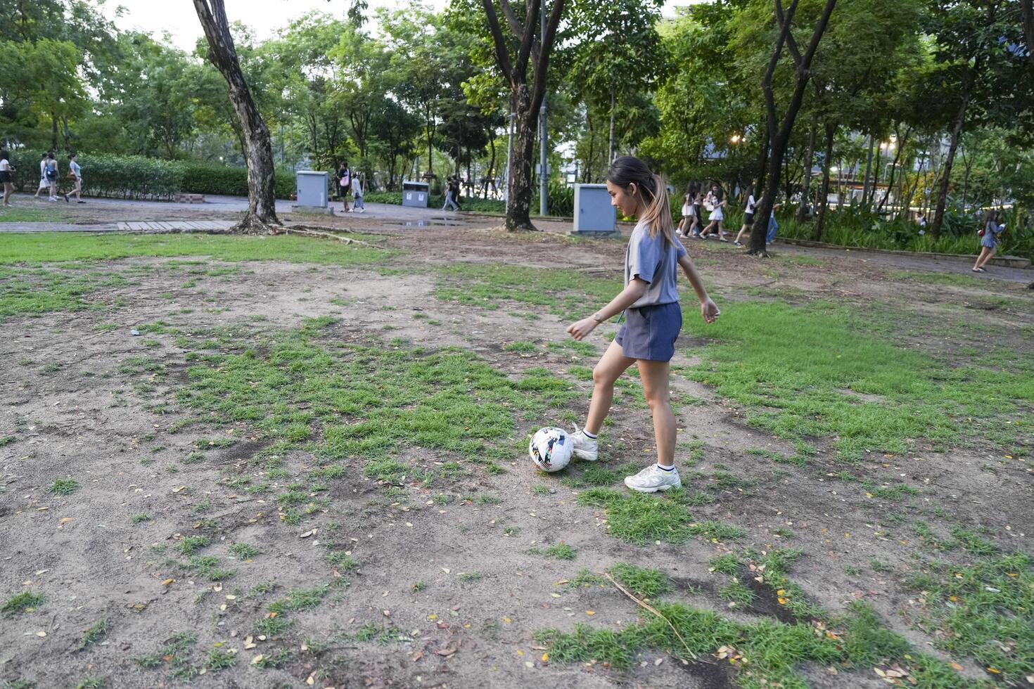 Male and female soccer players practice using the ball in the park field diligently and happily. photo