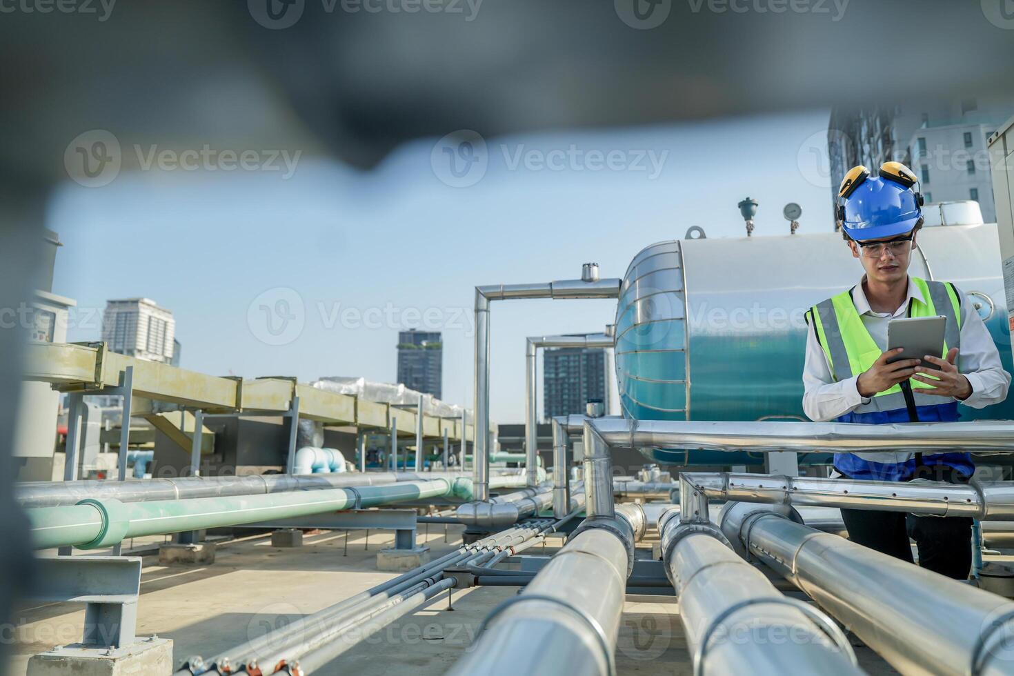 Urban rooftop scene showing a young engineer with a radio, inspecting and adjusting equipment in a sunny city environment. Safety and precision at work. photo