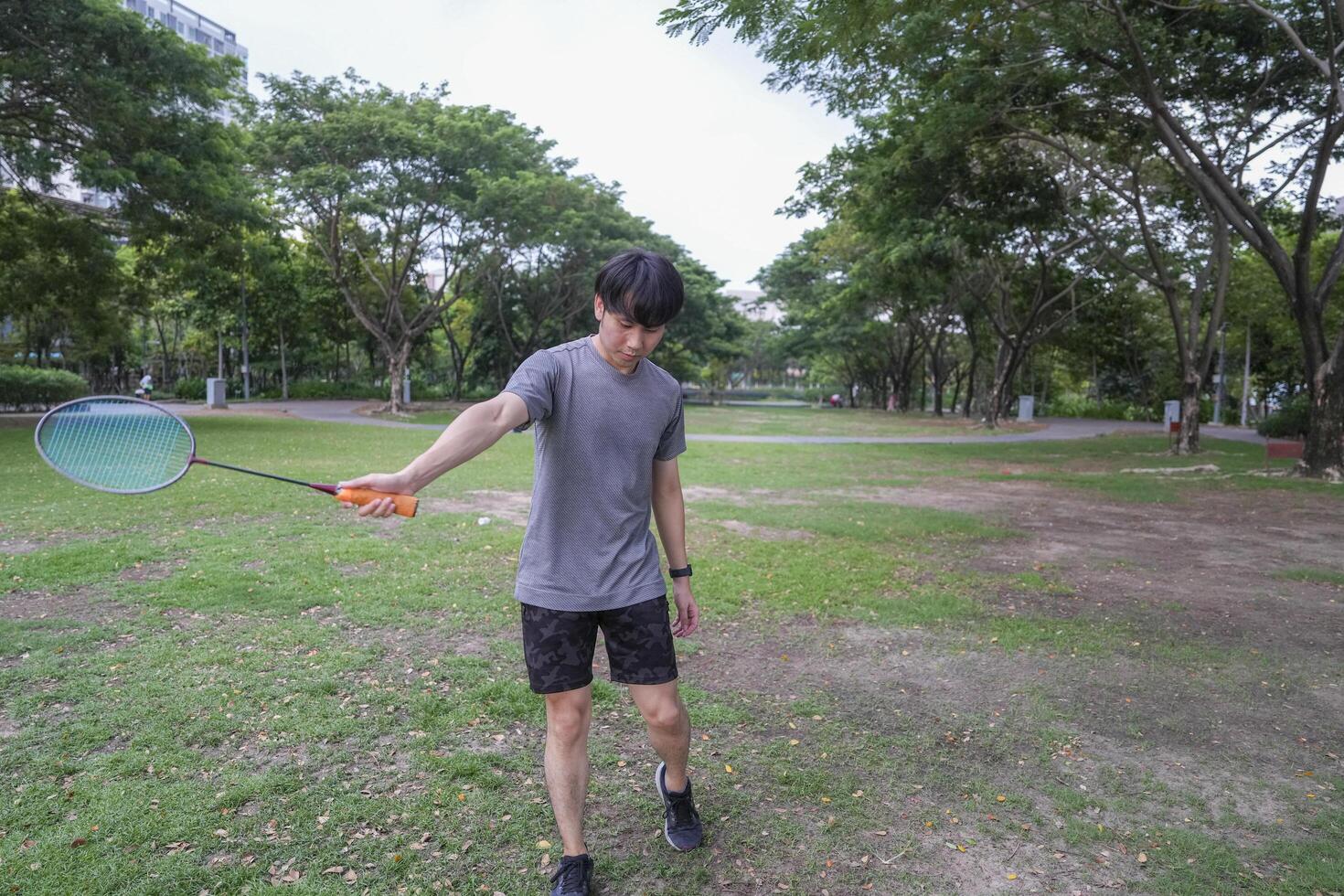 Young people play badminton and repair diligently in the park area. photo
