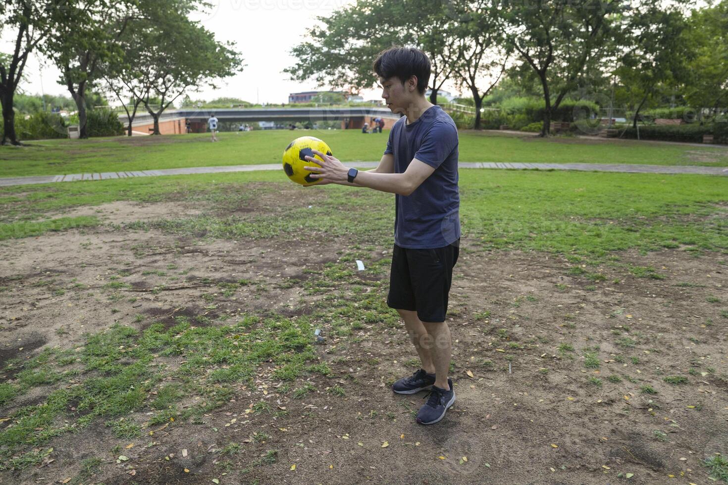 Male soccer players practice using the ball in the park field diligently and happily. photo