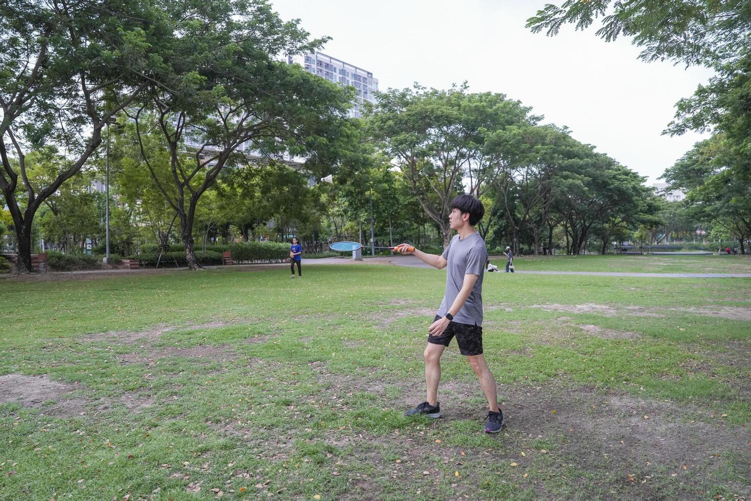 Young people play badminton and repair diligently in the park area. photo