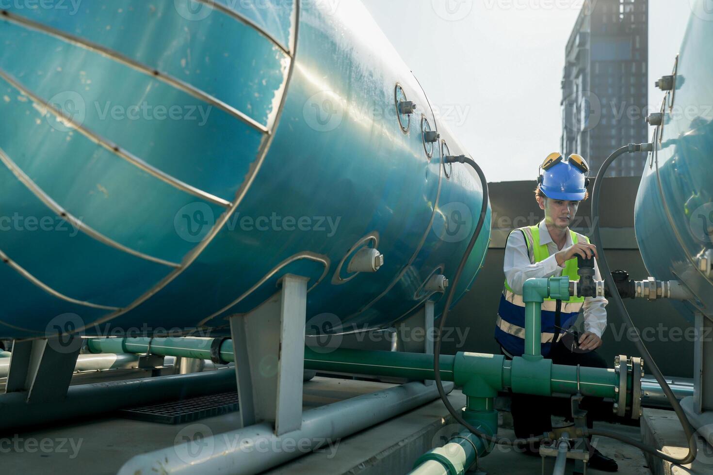 Urban rooftop scene showing a young engineer with a radio, inspecting and adjusting equipment in a sunny city environment. Safety and precision at work. photo