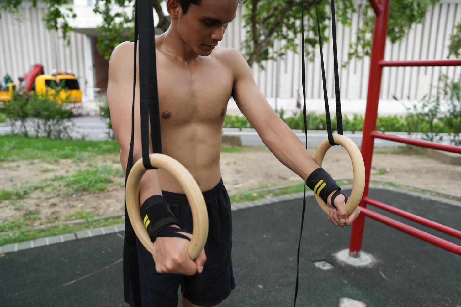 Asian man practicing gymnastics, doing gymnastics bar and hoop exercises and stretching, resting for sports. photo