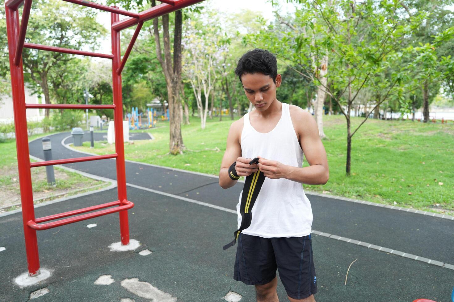 Asian man practicing gymnastics doing gymnastics bar and hoop exercises and stretching and resting for sports. photo
