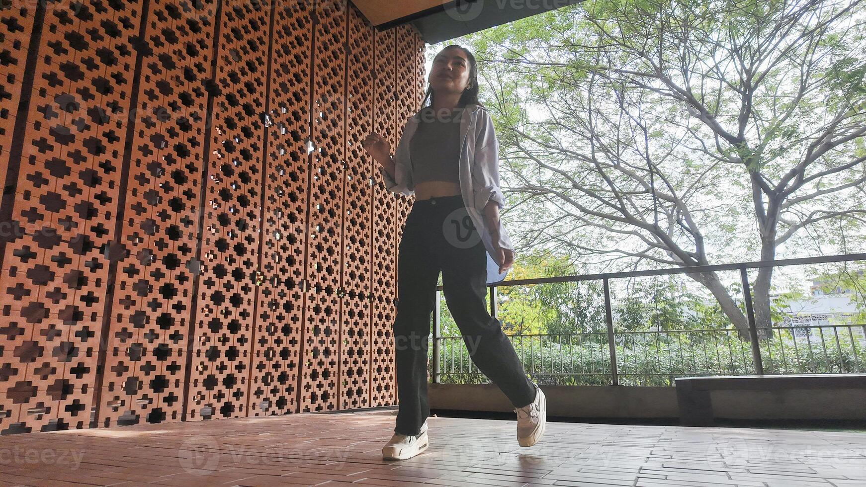 Asian girl dances freestyle hip-hop in an open space. photo
