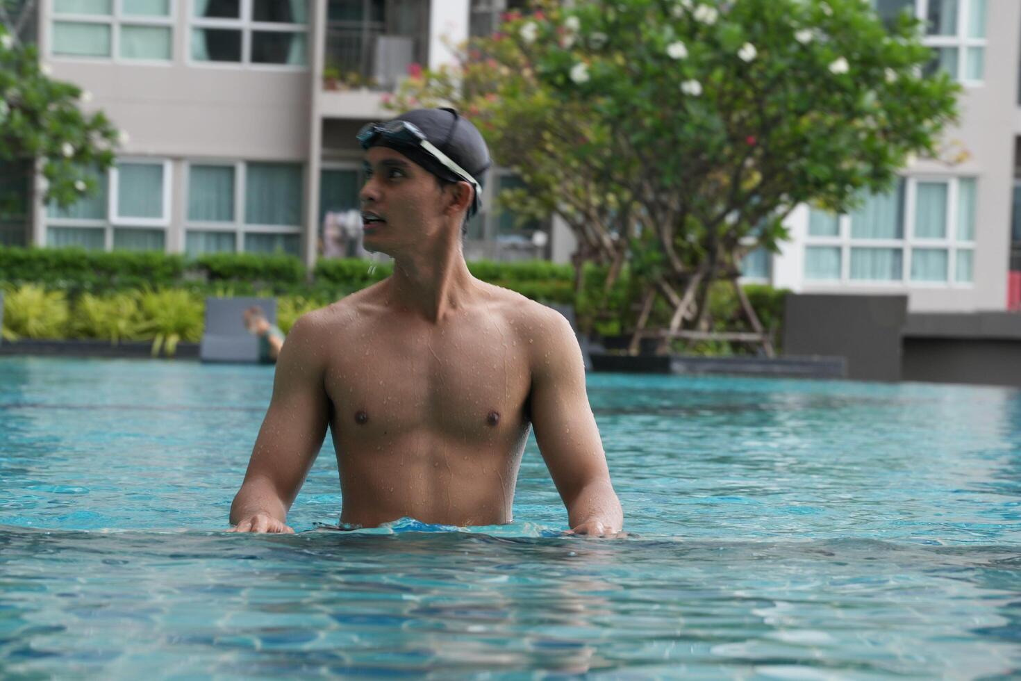 Asian men practicing swimming and preparing to play water polo and stretching and resting for water sports. photo