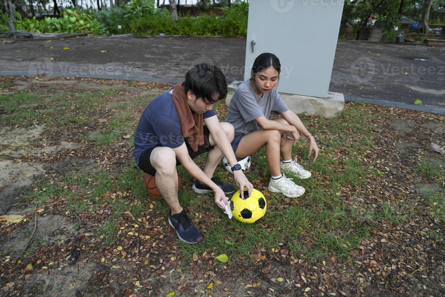 Male and female soccer players practice using the ball in the park field diligently and happily. photo