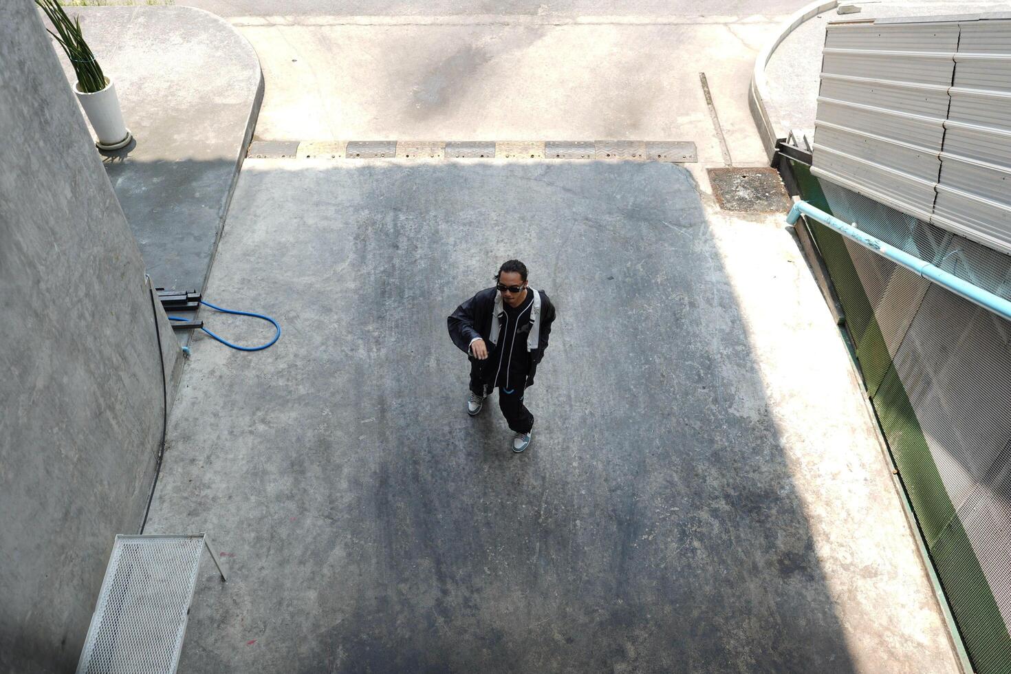 ASian man is dancing in hip hop style at outdoor space. Professional solo dancer is performing in public area. photo