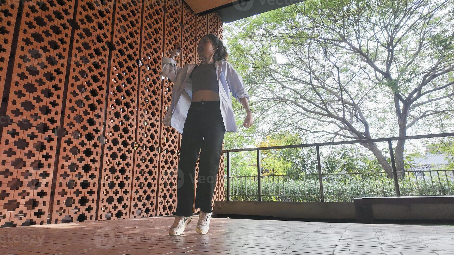 Asian girl dances freestyle hip-hop in an open space. photo