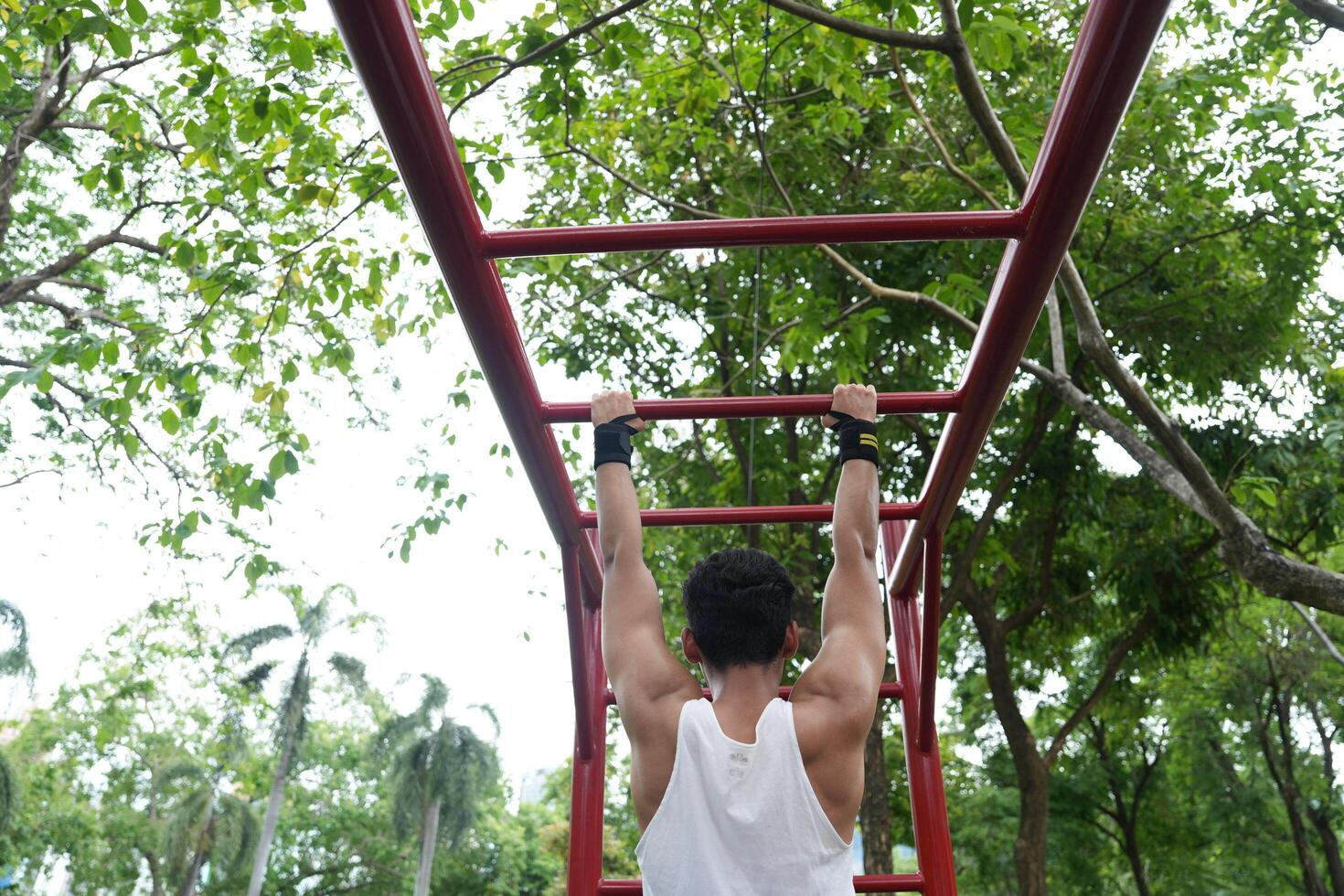 Asian man practicing gymnastics, doing gymnastics bar and hoop exercises and stretching, resting for sports. photo