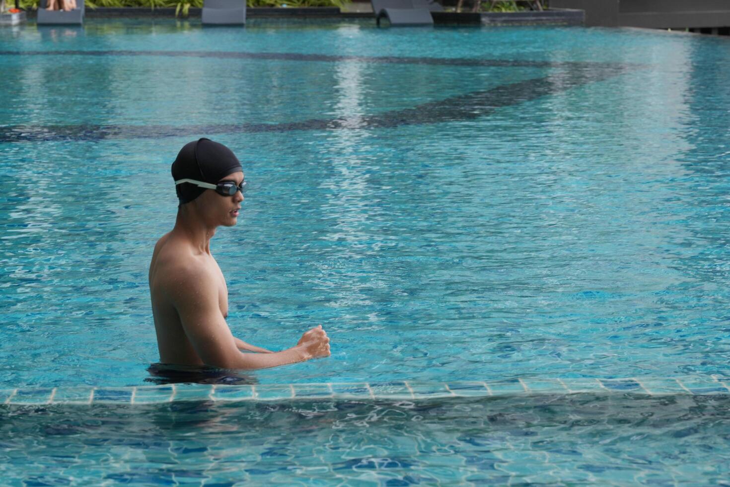 Asian men practicing swimming and preparing to play water polo and stretching and resting for water sports. photo