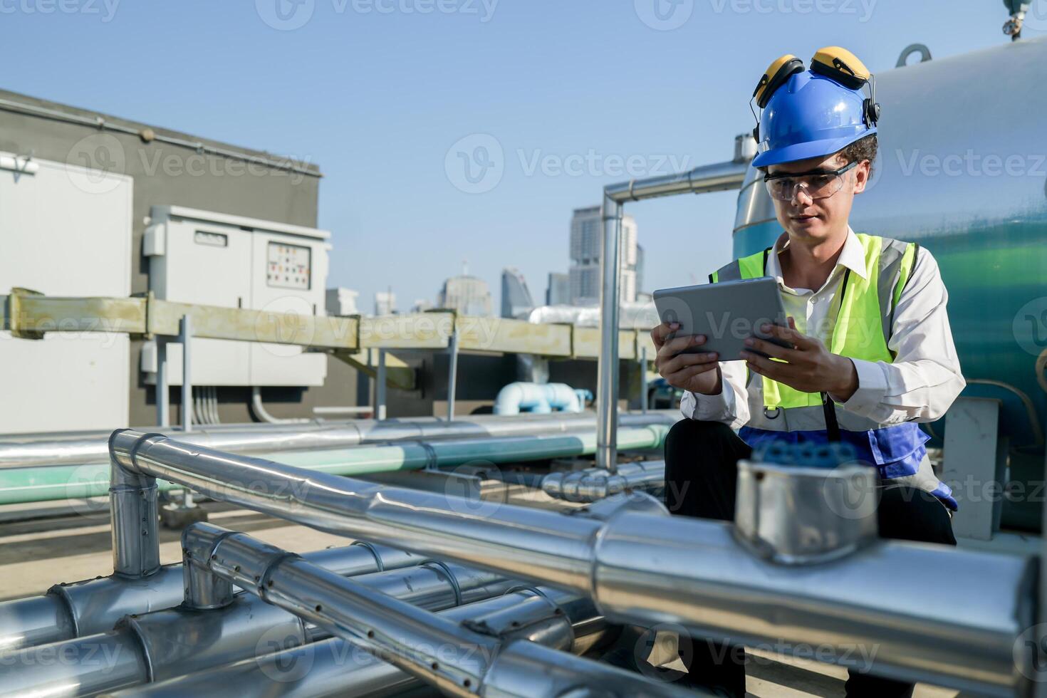 Urban rooftop scene showing a young engineer with a radio, inspecting and adjusting equipment in a sunny city environment. Safety and precision at work. photo