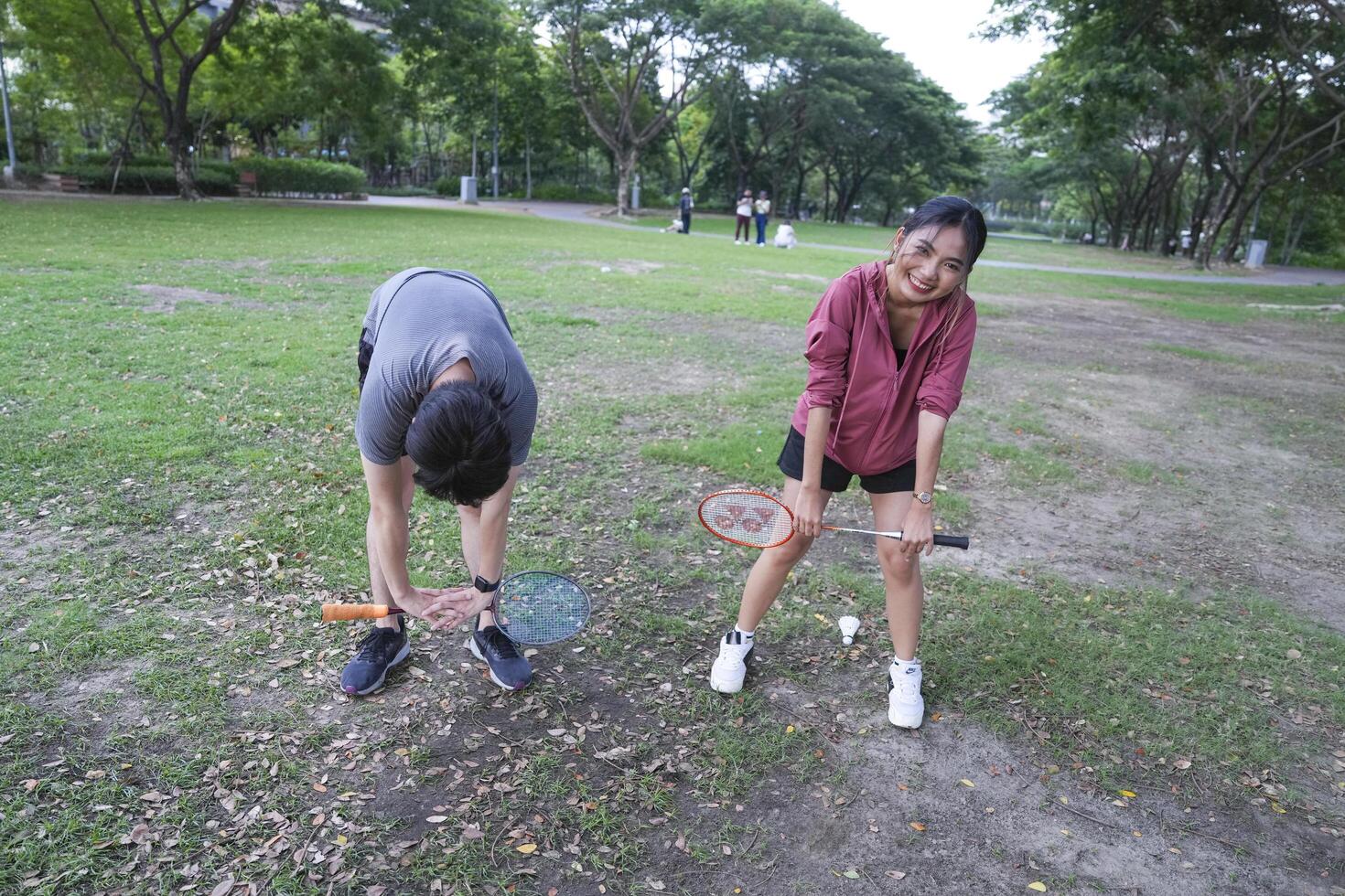Young people play badminton and repair diligently in the park area. photo