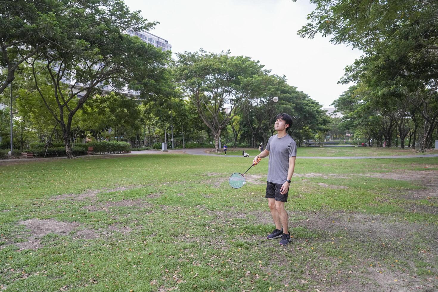 Young people play badminton and repair diligently in the park area. photo