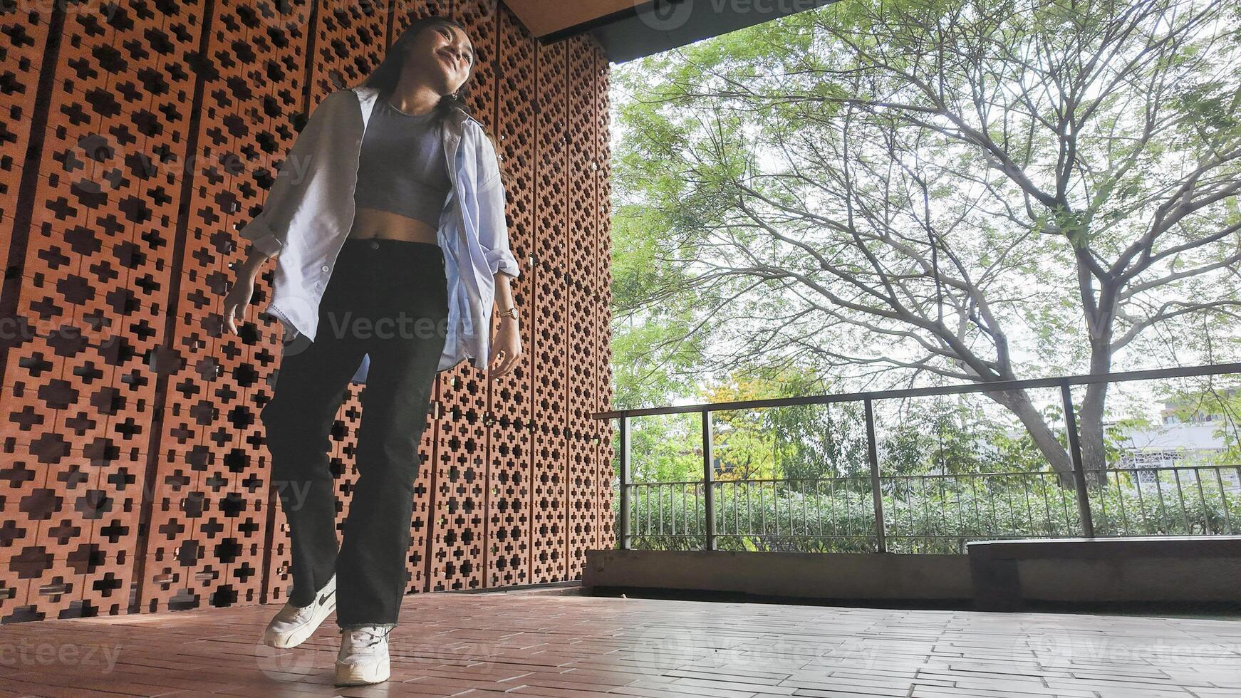 Asian girl dances freestyle hip-hop in an open space. photo