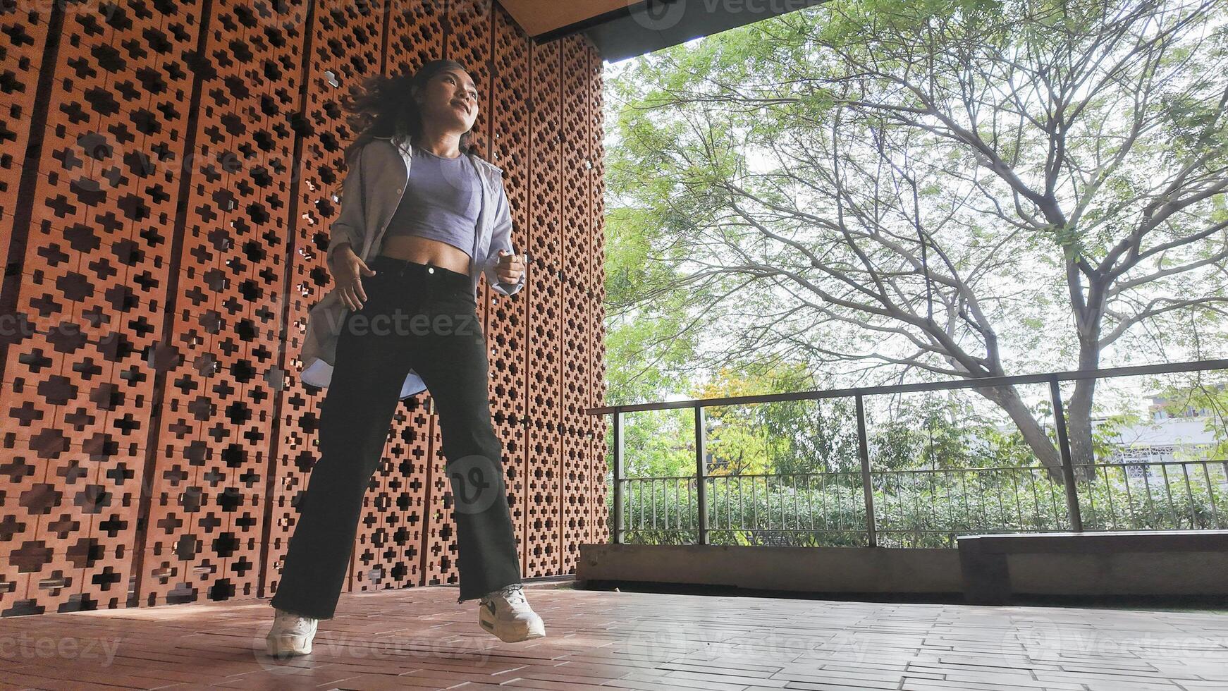 Asian girl dances freestyle hip-hop in an open space. photo