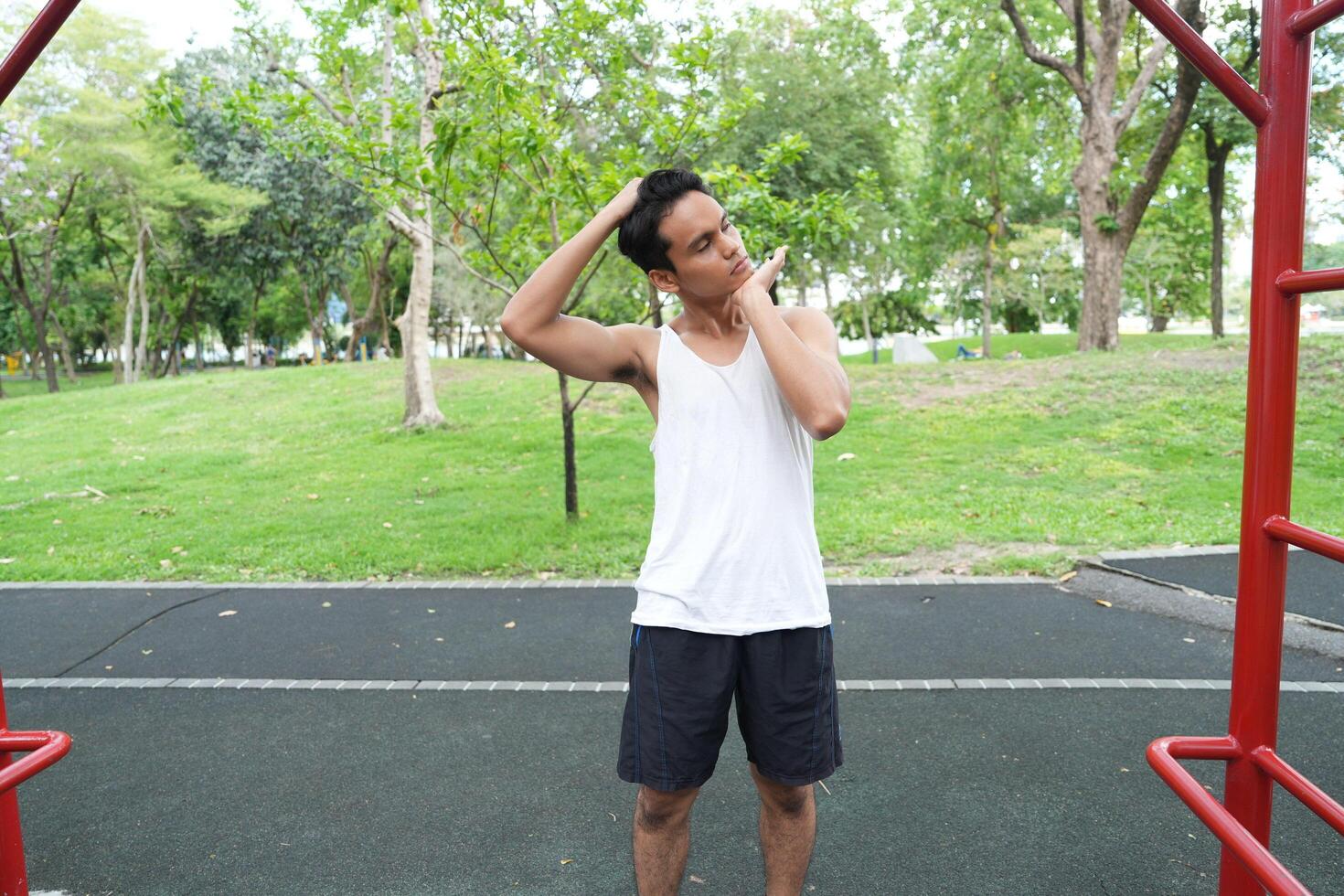 Asian man practicing gymnastics doing gymnastics bar and hoop exercises and stretching and resting for sports. photo