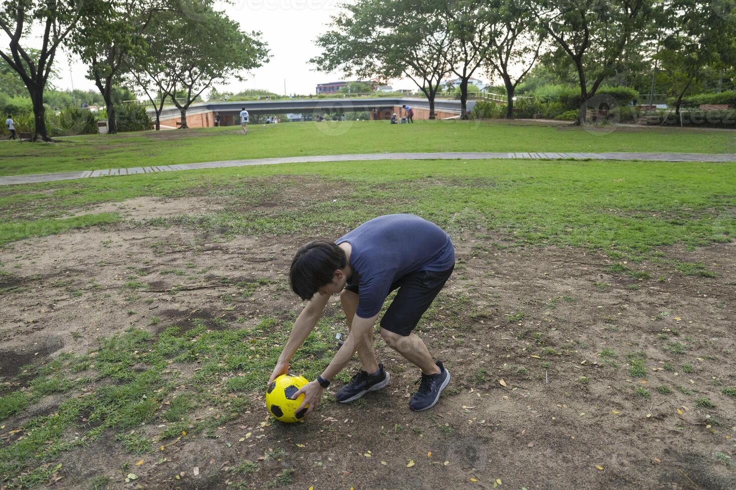 Male soccer players practice using the ball in the park field diligently and happily. photo