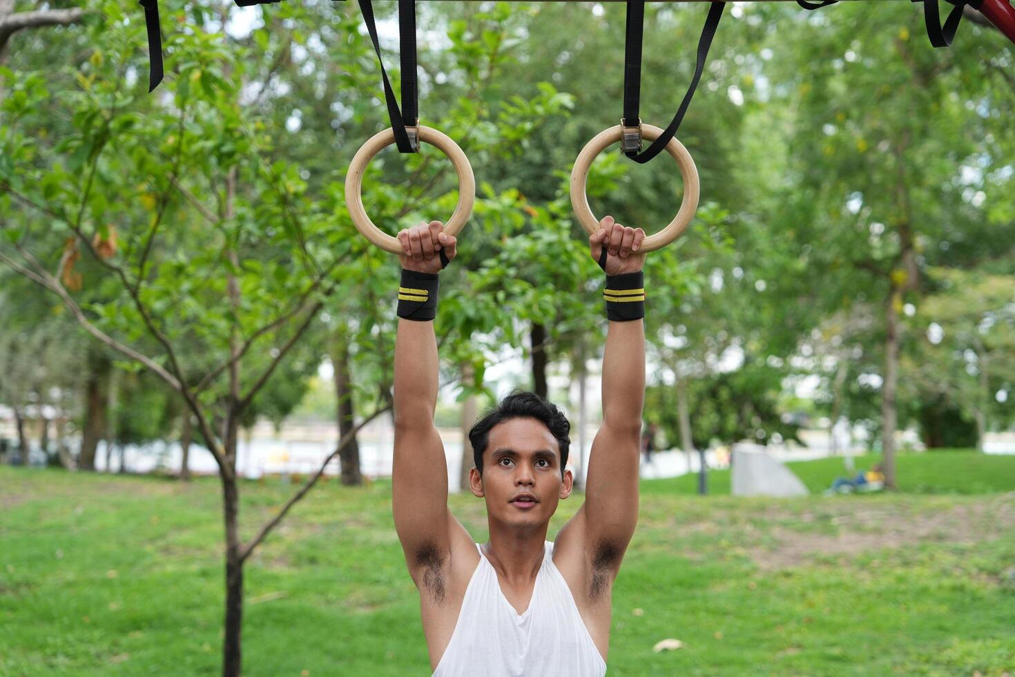 Asian man practicing gymnastics doing gymnastics bar and hoop exercises and stretching and resting for sports. photo