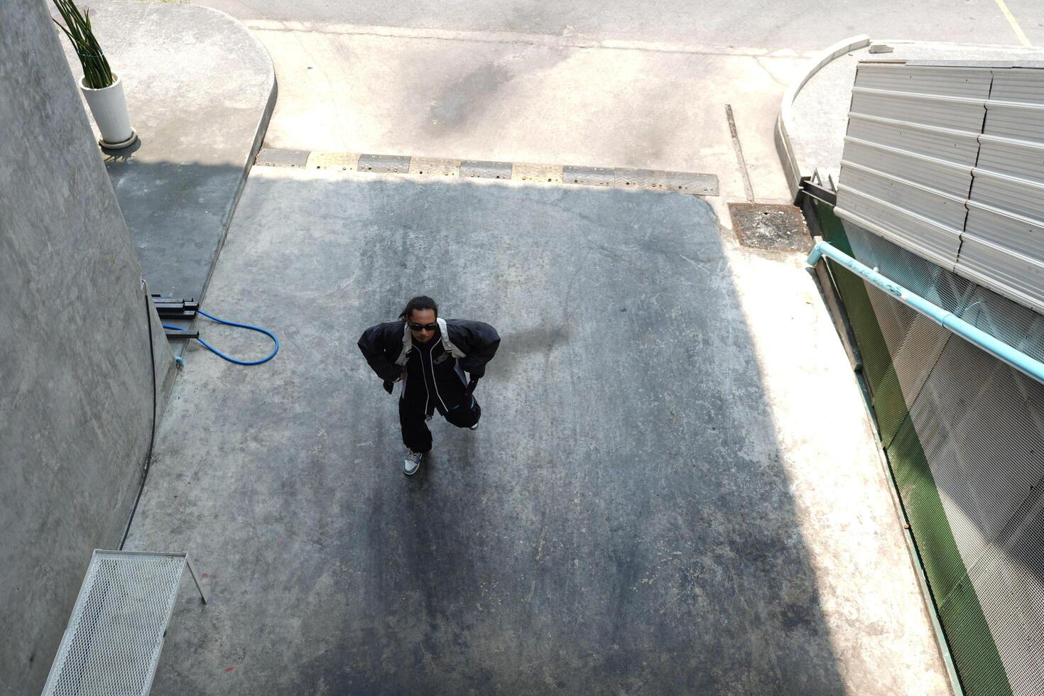 ASian man is dancing in hip hop style at outdoor space. Professional solo dancer is performing in public area. photo