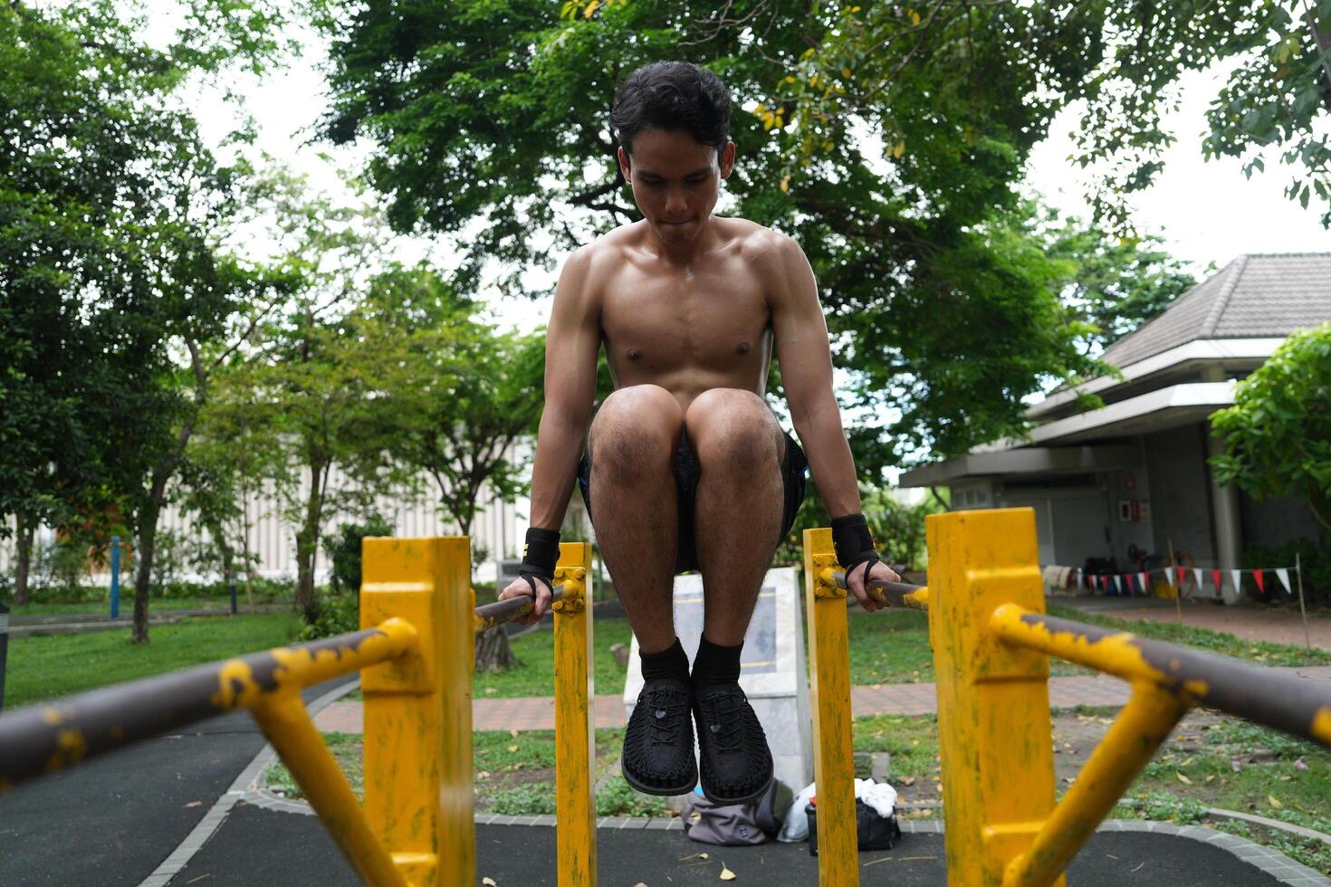 Asian man practicing gymnastics, doing gymnastics bar and hoop exercises and stretching, resting for sports. photo