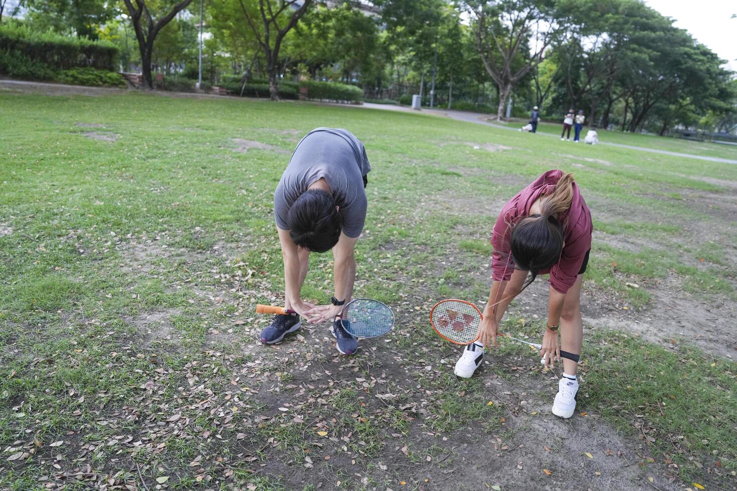Young people play badminton and repair diligently in the park area. photo