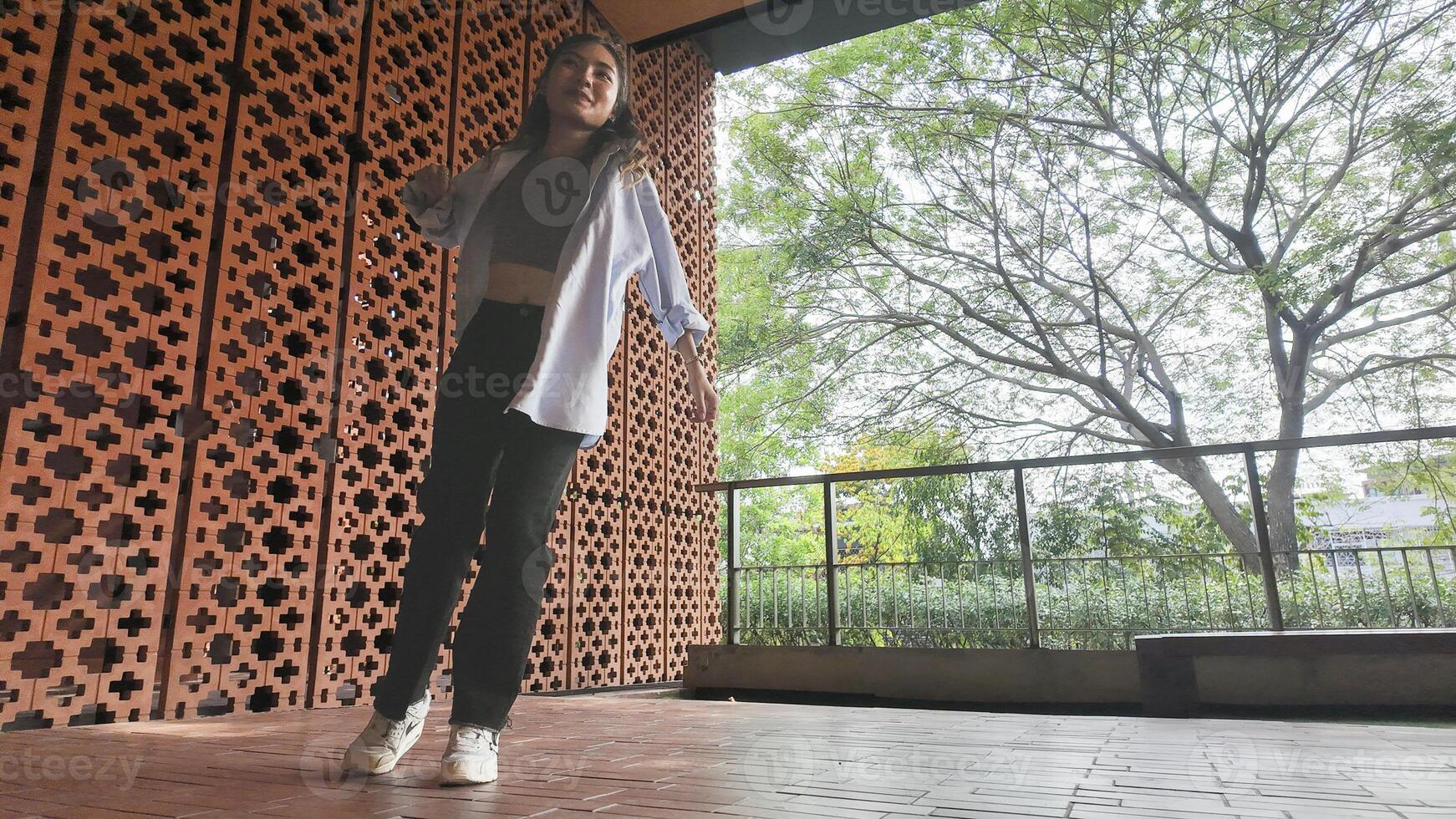 Asian girl dances freestyle hip-hop in an open space. photo