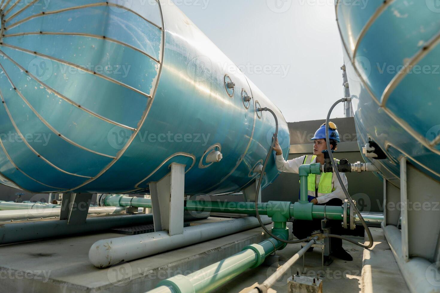 Urban rooftop scene showing a young engineer with a radio, inspecting and adjusting equipment in a sunny city environment. Safety and precision at work. photo