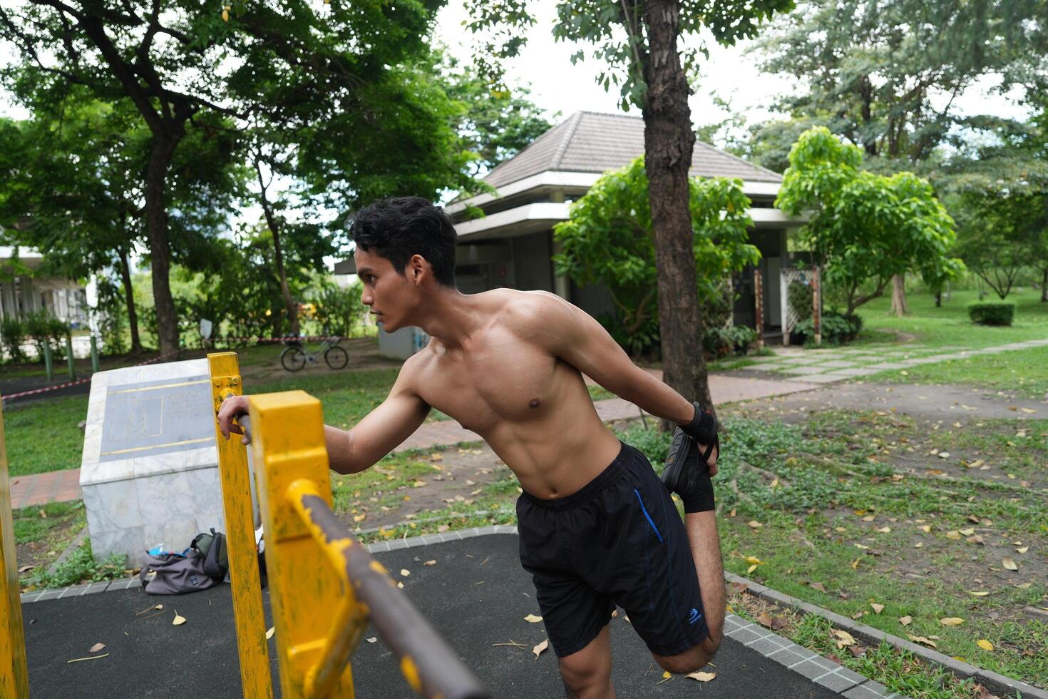 Asian man practicing gymnastics, doing gymnastics bar and hoop exercises and stretching, resting for sports. photo