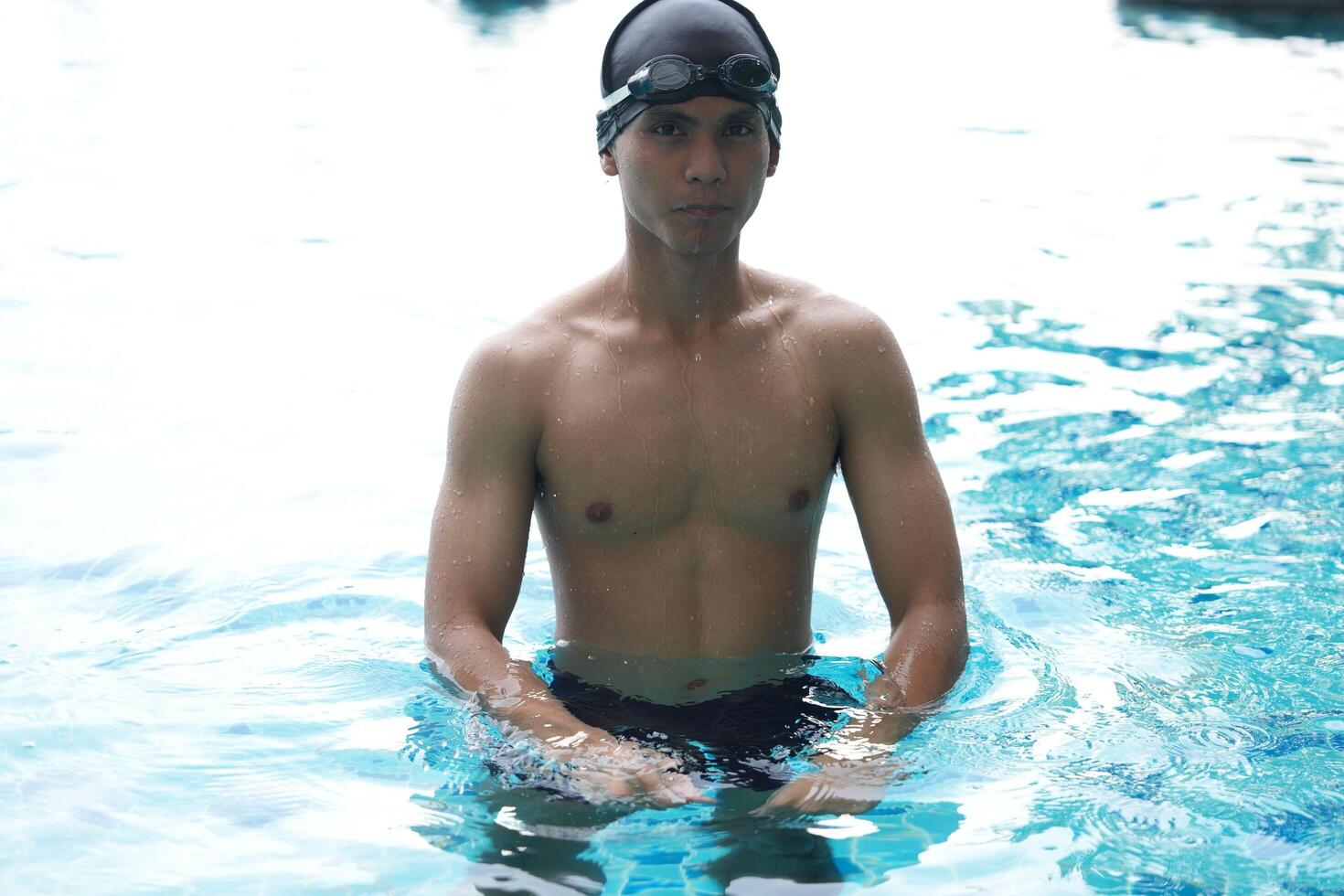 Asian men practicing swimming and preparing to play water polo and stretching and resting for water sports. photo