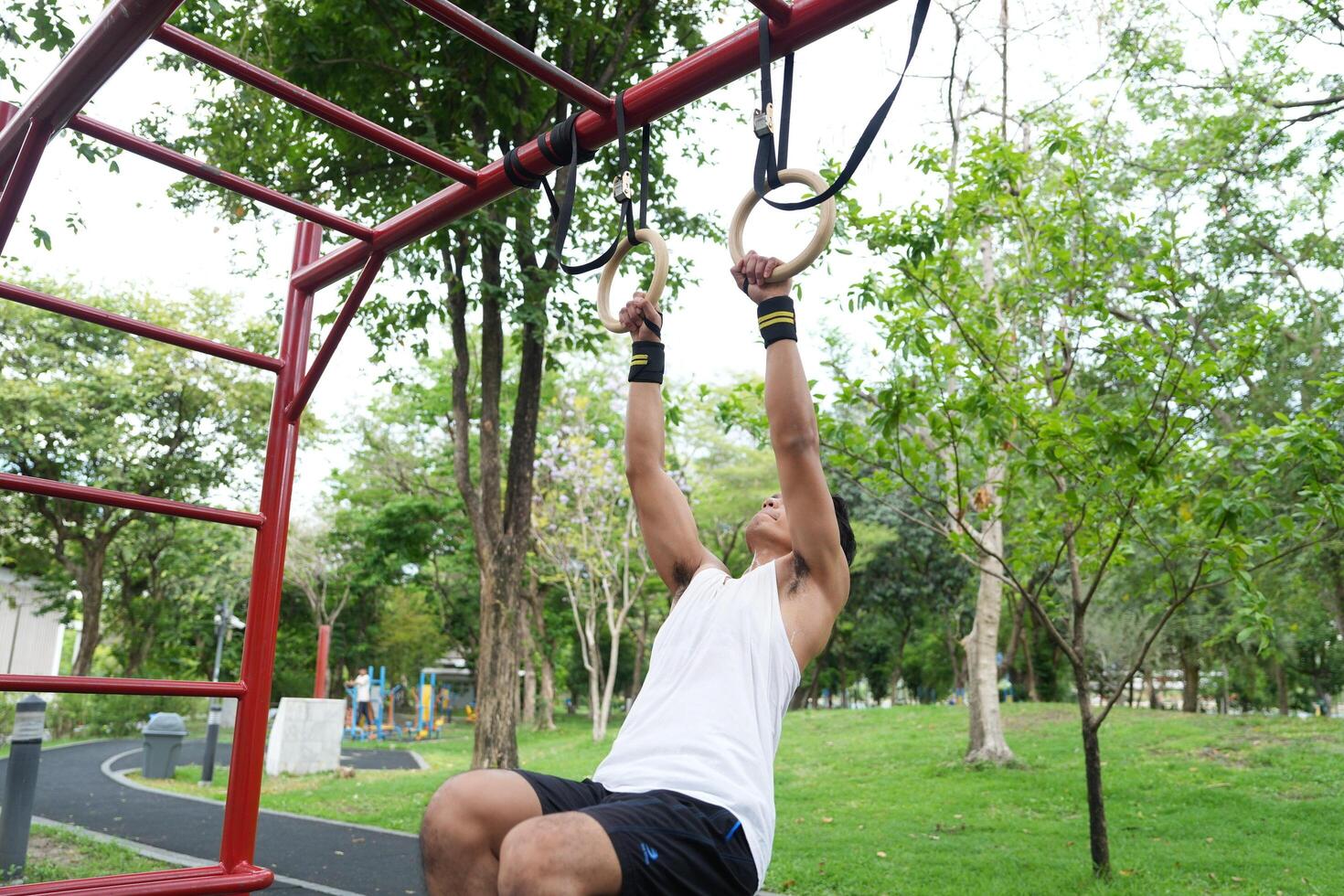 Asian man practicing gymnastics, doing gymnastics bar and hoop exercises and stretching, resting for sports. photo