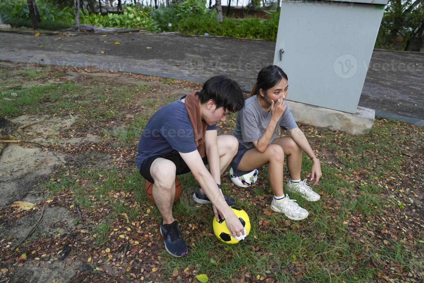 Male and female soccer players practice using the ball in the park field diligently and happily. photo