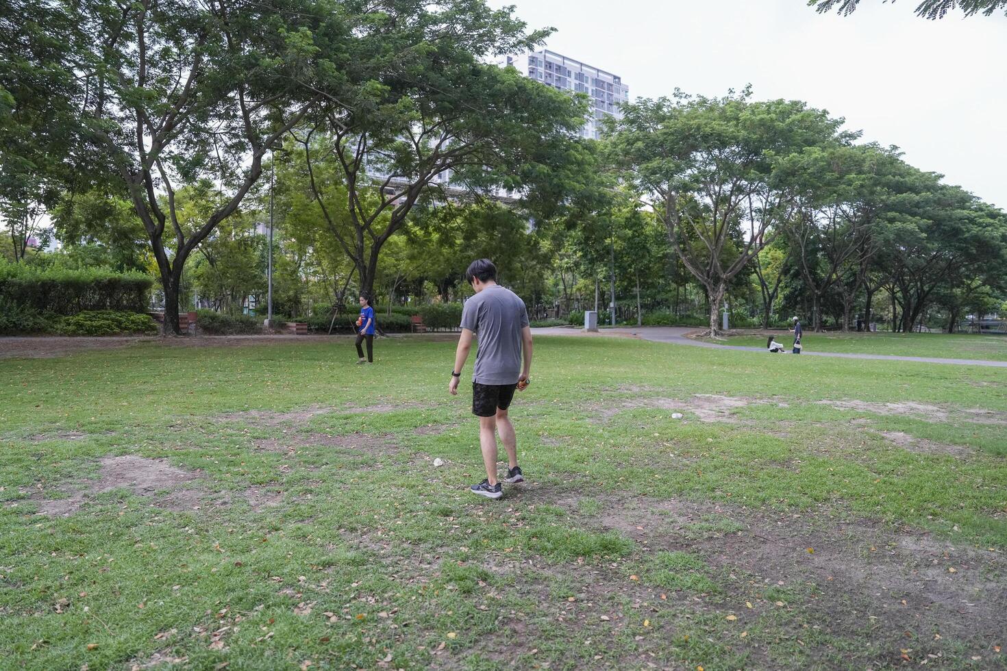 Young people play badminton and repair diligently in the park area. photo