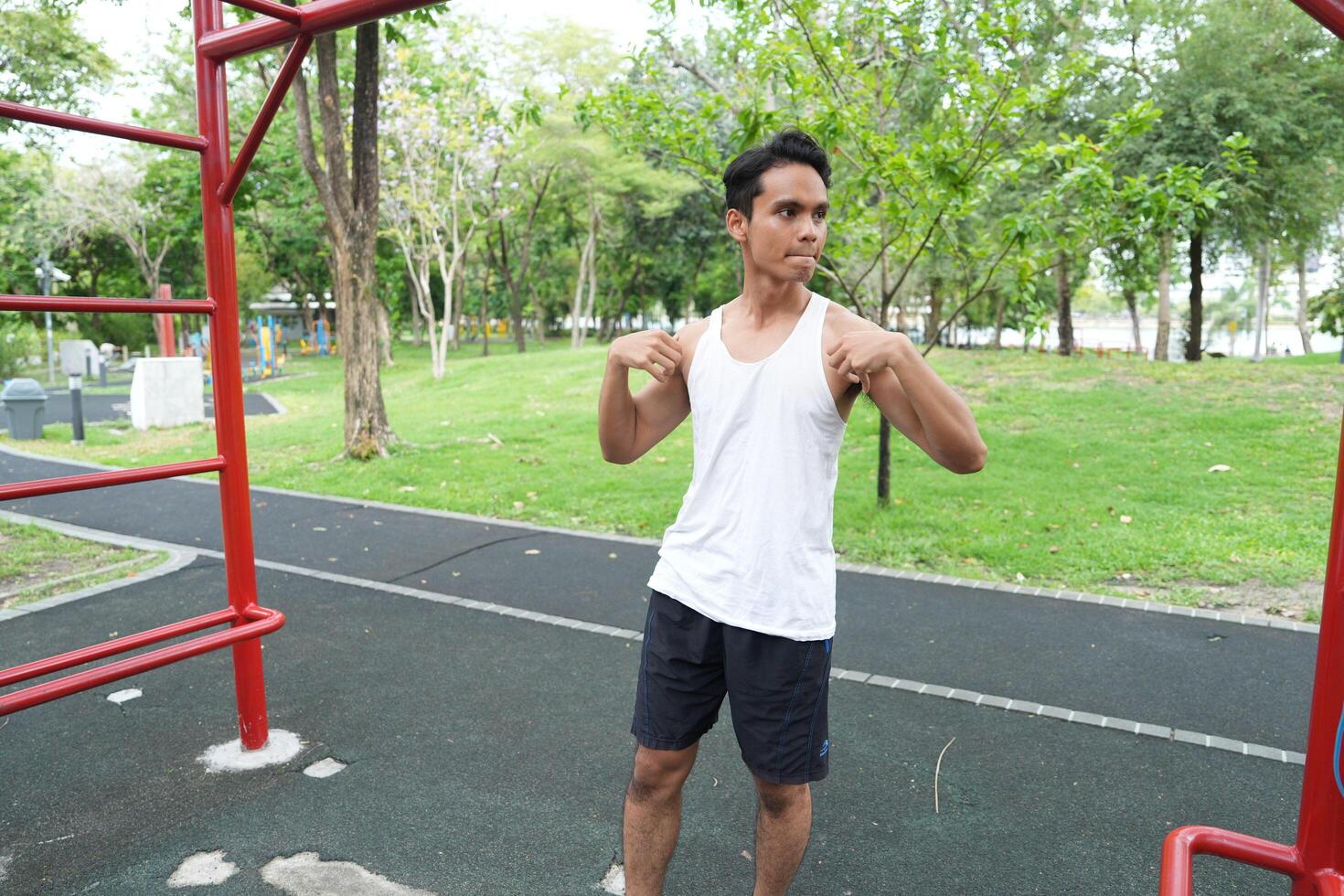 Asian man practicing gymnastics doing gymnastics bar and hoop exercises and stretching and resting for sports. photo