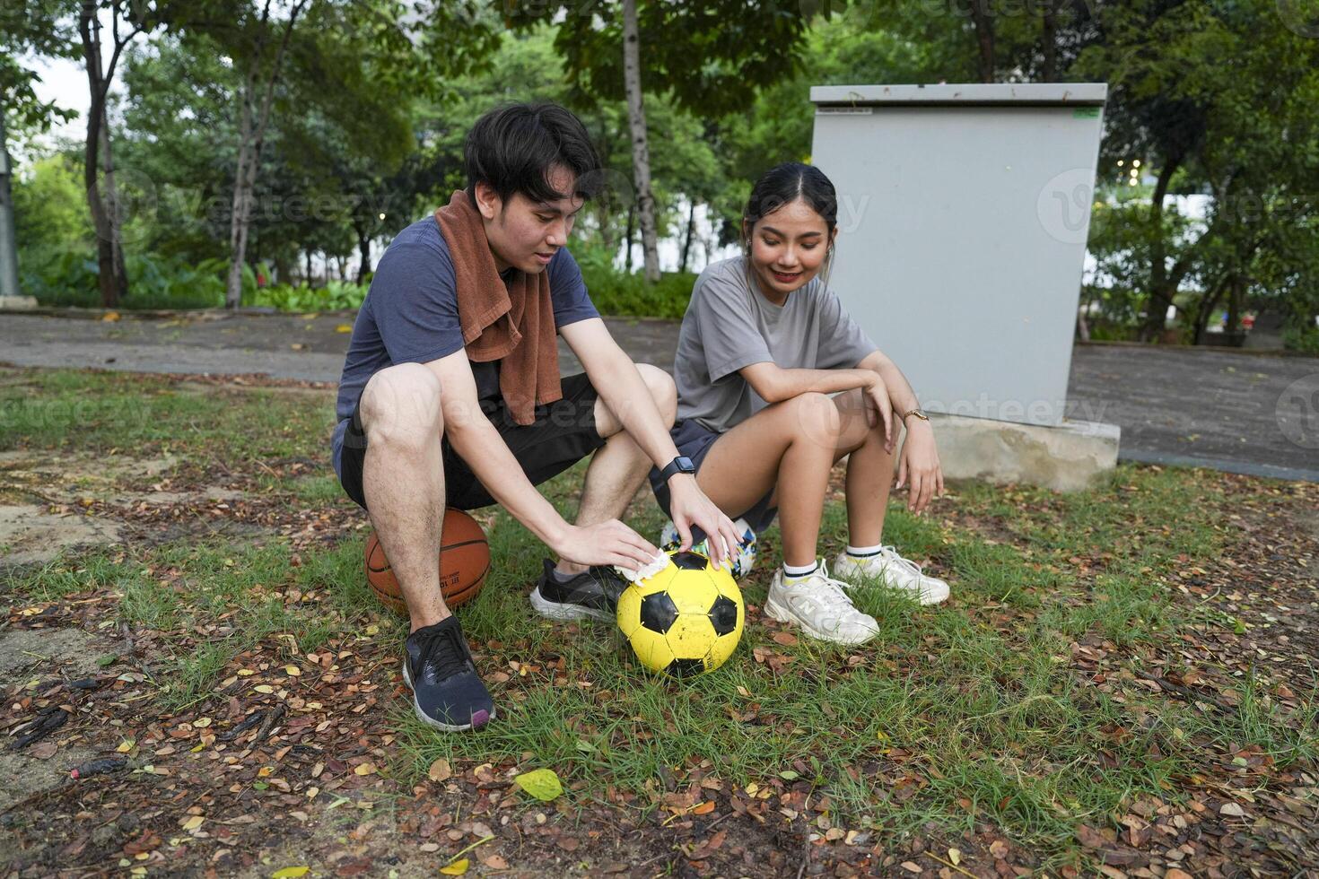 Male and female soccer players practice using the ball in the park field diligently and happily. photo
