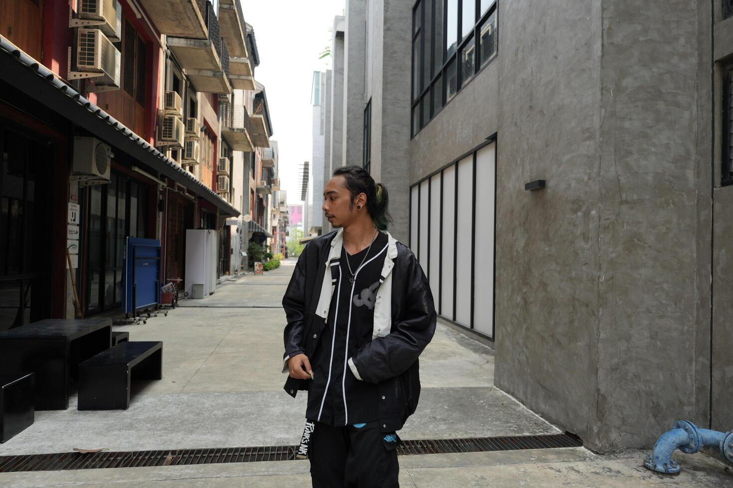ASian man is dancing in hip hop style at outdoor space. Professional solo dancer is performing in public area. photo