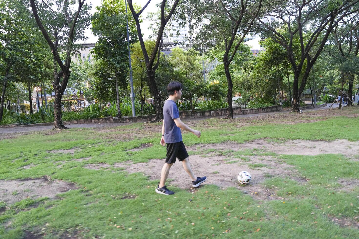 Asian man are running and Kicking ball for playing a soccer at outdoor park. photo