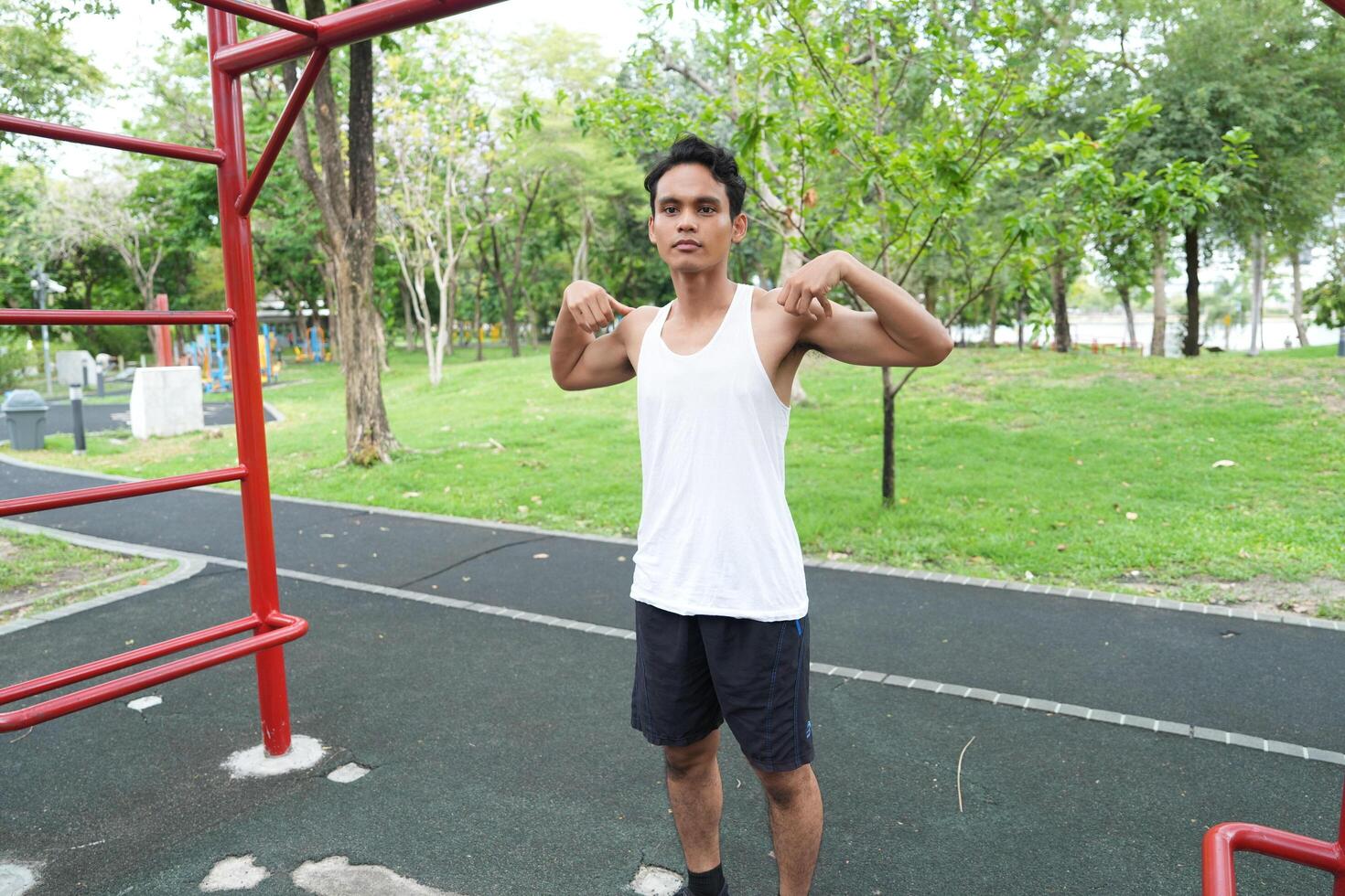 Asian man practicing gymnastics doing gymnastics bar and hoop exercises and stretching and resting for sports. photo