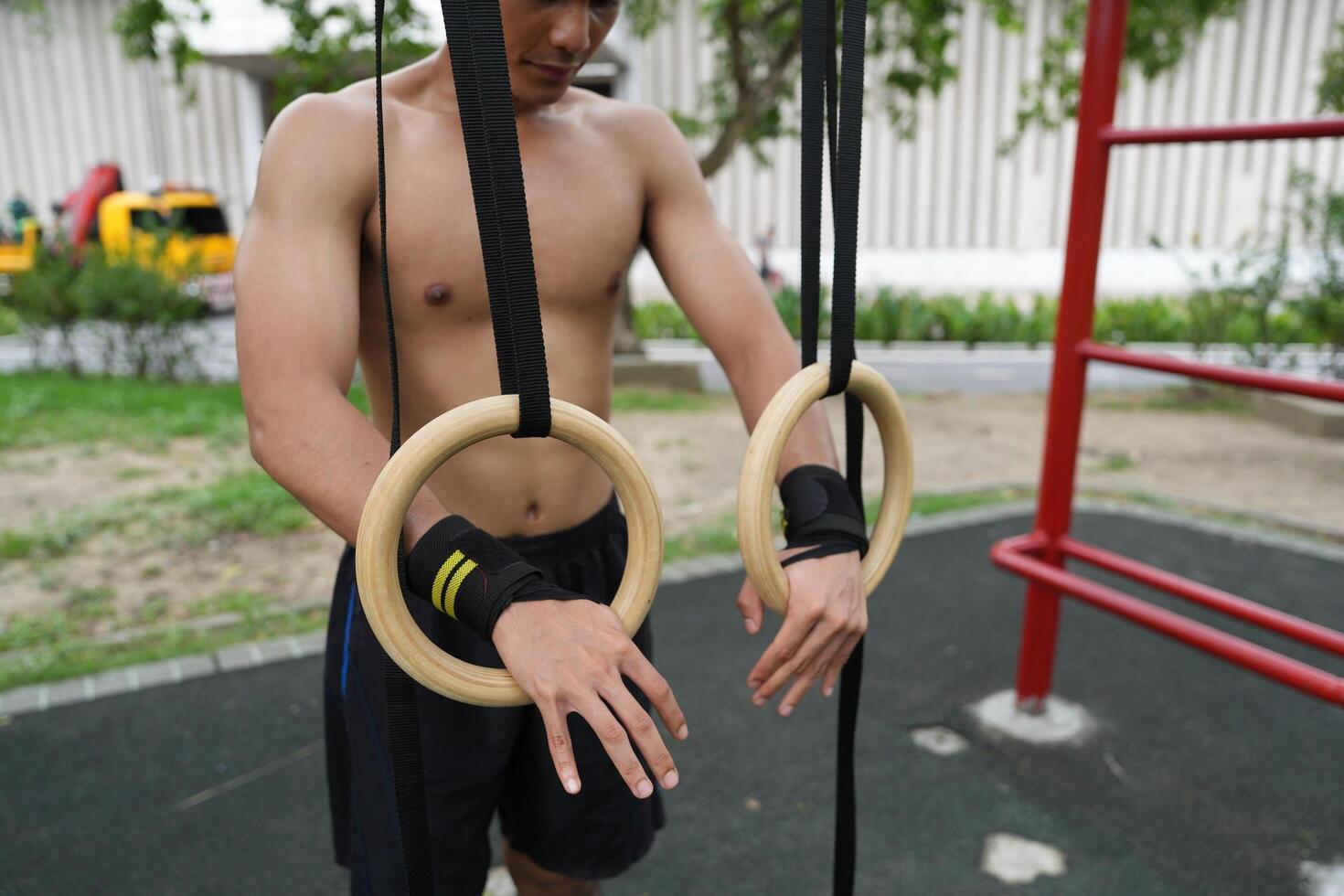 Asian man practicing gymnastics, doing gymnastics bar and hoop exercises and stretching, resting for sports. photo