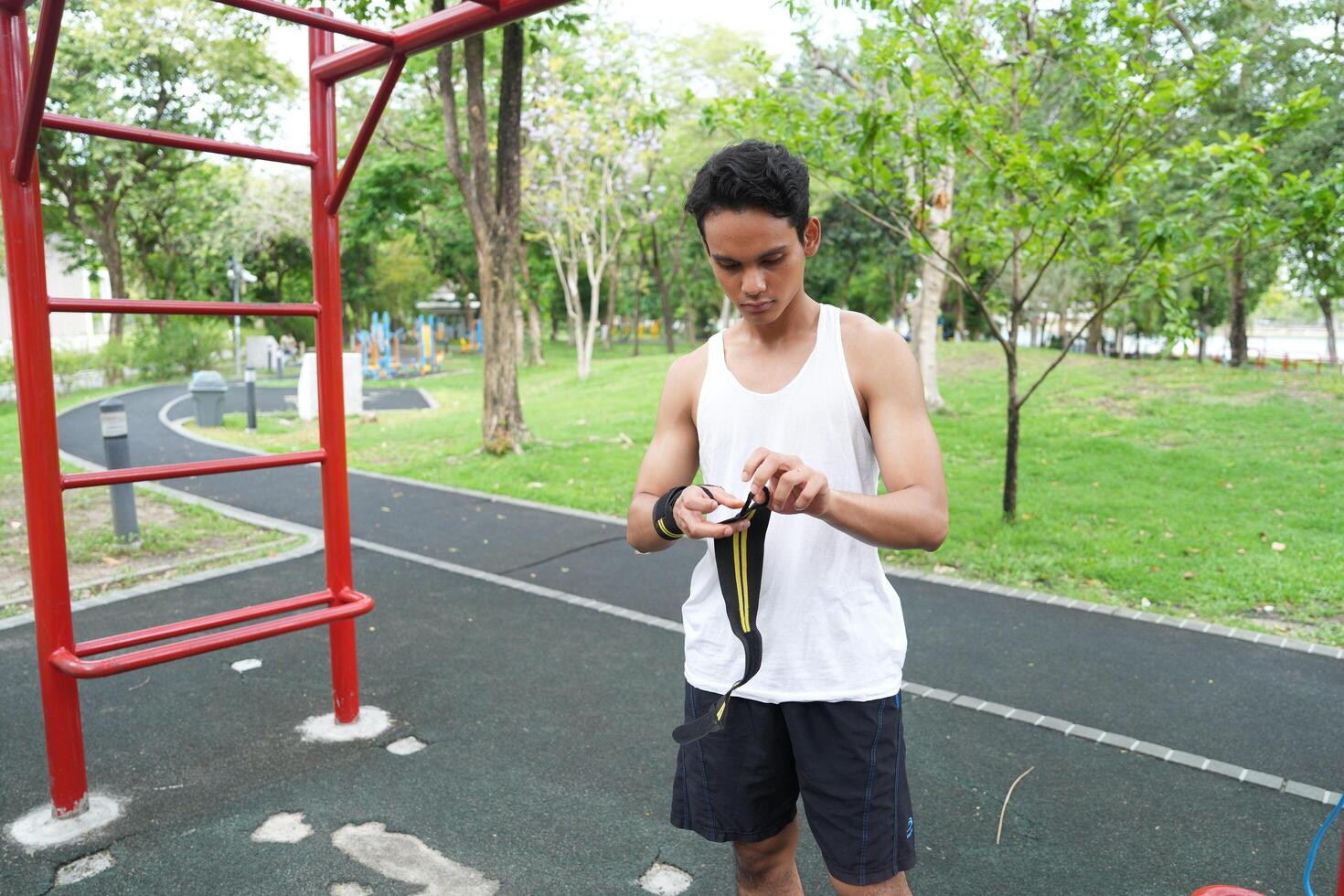 Asian man practicing gymnastics doing gymnastics bar and hoop exercises and stretching and resting for sports. photo