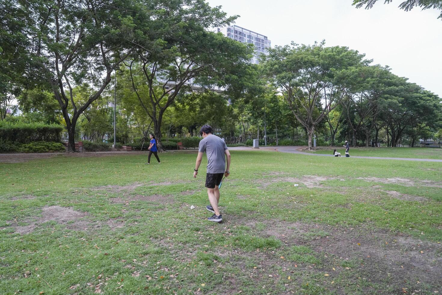 Young people play badminton and repair diligently in the park area. photo