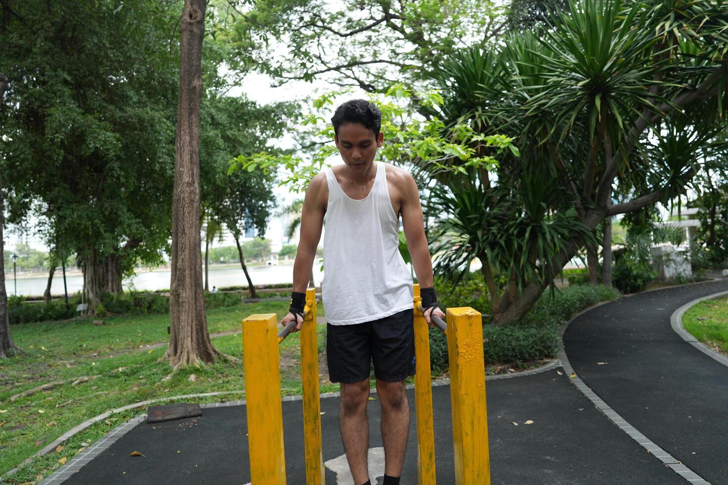 Asian man practicing gymnastics, doing gymnastics bar and hoop exercises and stretching, resting for sports. photo