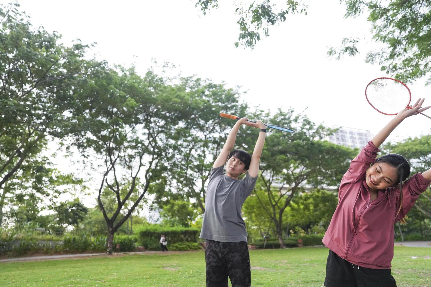 Young people play badminton and repair diligently in the park area. photo