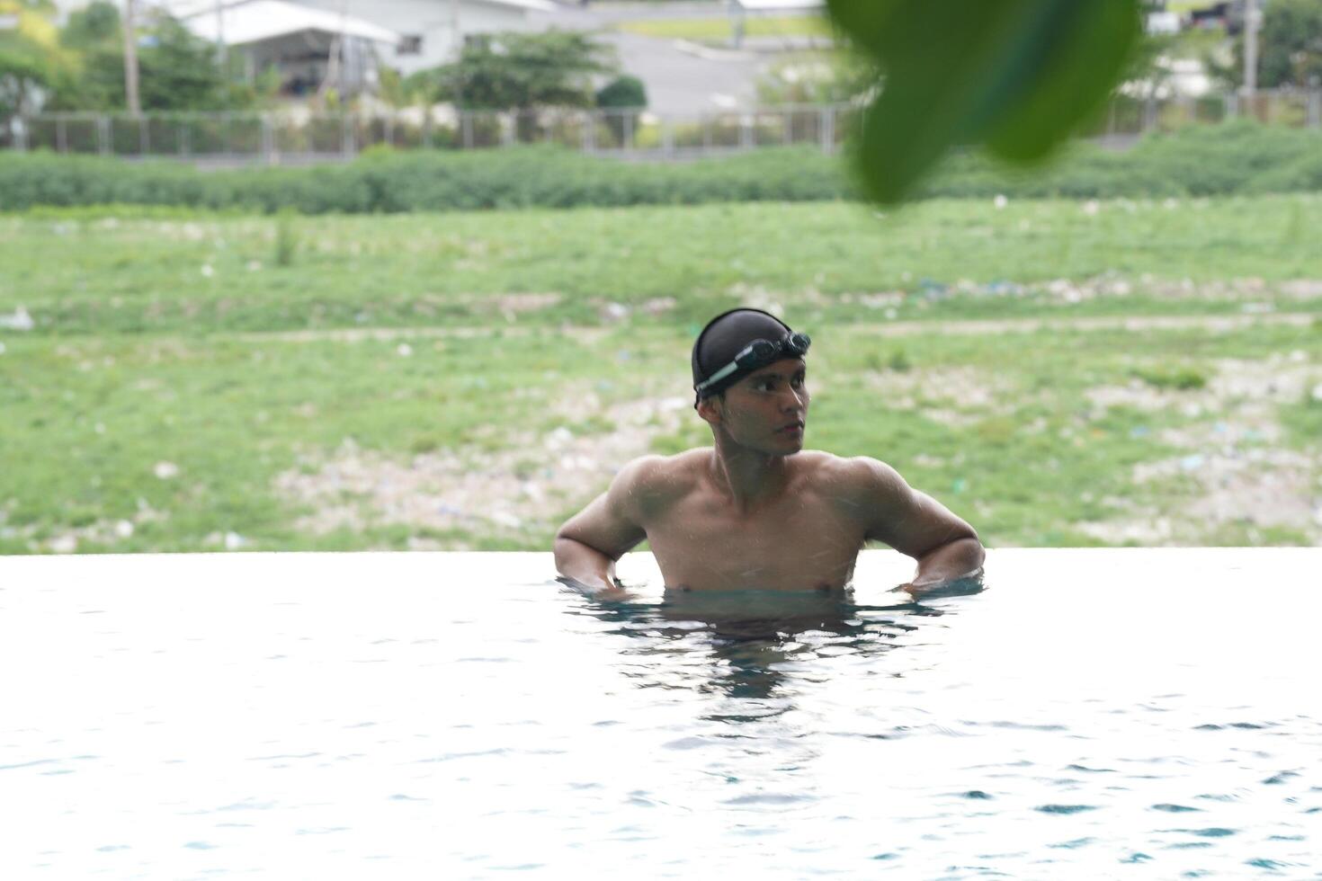 Asian men practicing swimming and preparing to play water polo and stretching and resting for water sports. photo