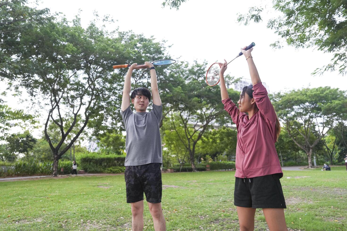 Young people play badminton and repair diligently in the park area. photo